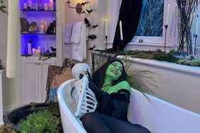 Kylie Jenner painted green lies in a bathtub