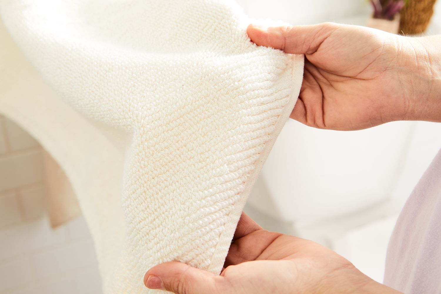 Closeup hands displaying Coyuchi Air Weight Organic Towels