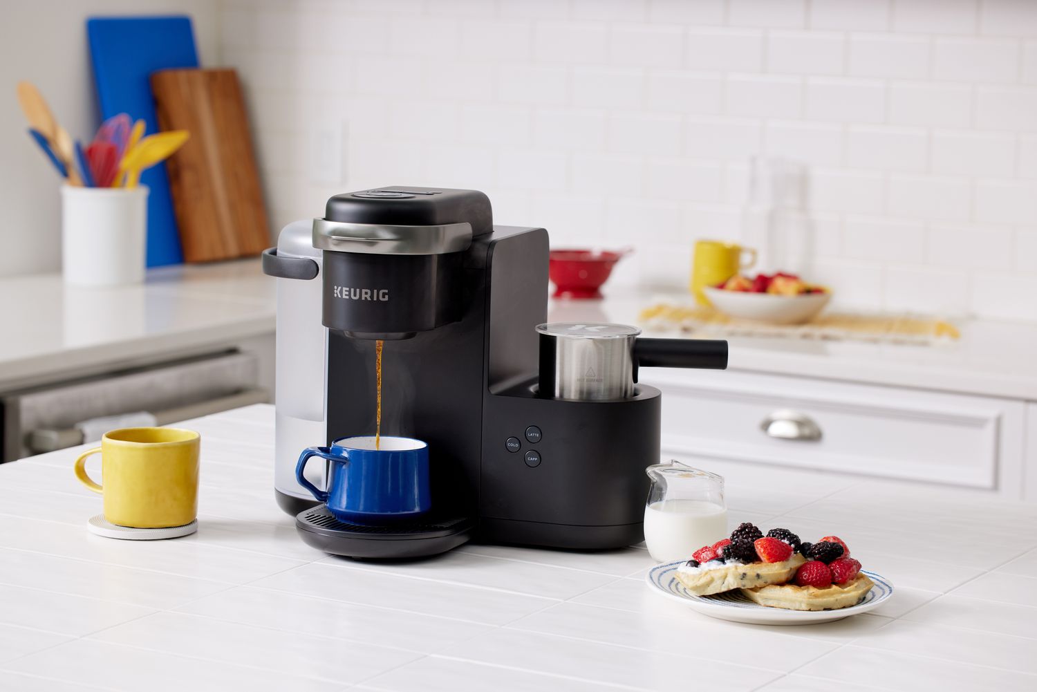 Keurig K-Café Single-Serve K-Cup Coffee Maker pouring coffee into a cup next to a plate of pancakes