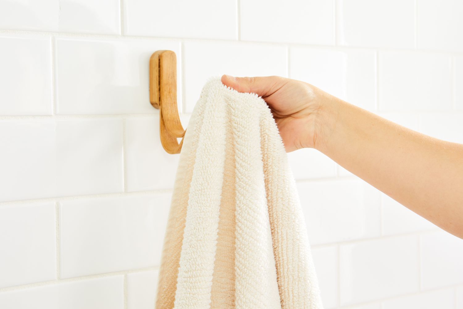 Person hanging Coyuchi Air Weight Organic Towels on hook