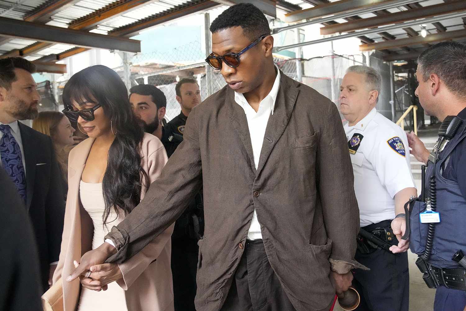 Jonathan Majors, center, and Meagan Good, left, leave court after a hearing on his domestic violence case