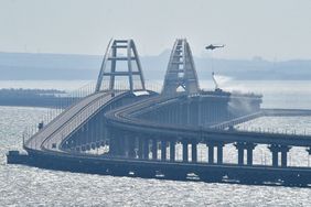 Mandatory Credit: Photo by Uncredited/AP/Shutterstock (13448163a) Helicopter drops water to stop fire on Crimean Bridge connecting Russian mainland and Crimean peninsula over the Kerch Strait, in Kerch, . Russian authorities say a truck bomb has caused a fire and the collapse of a section of a bridge linking Russia-annexed Crimea with Russia. The bridge is a key supply artery for Moscow's faltering war effort in southern Ukraine Russia Ukraine, Kerch - 08 Oct 2022