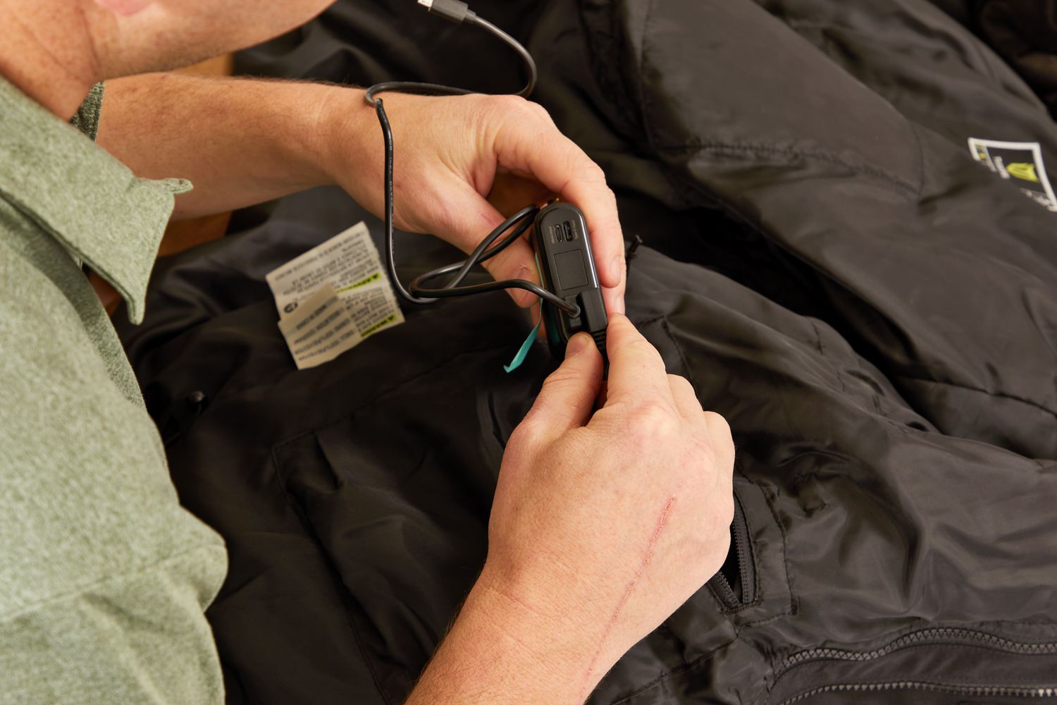 Person holding the battery pack for the TideWe Mens 3-in-1 Heated Jacket with Battery Pack