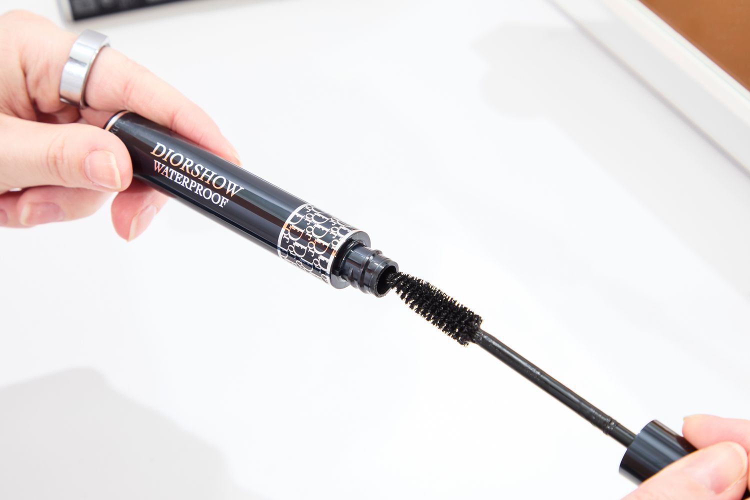 A person removes the cap and wand from the Dior Diorshow Waterproof Mascara