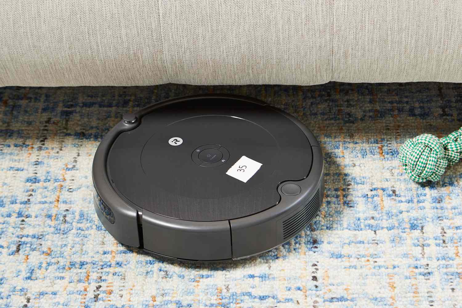 iRobot Roomba 694 Robot Vacuum on a rug next to a couch