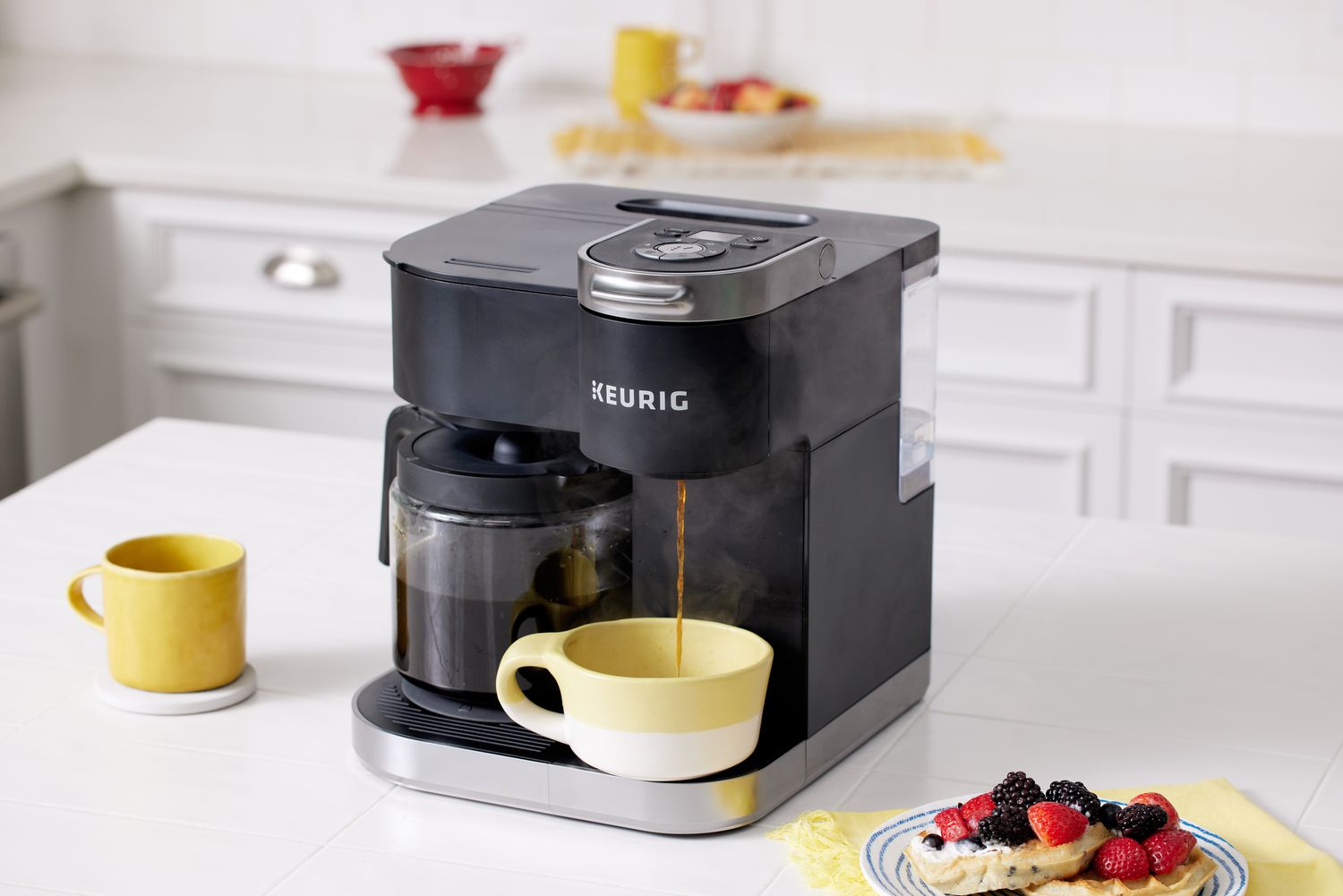 Keurig K-Duo Coffee Maker pouring coffee into a cup next to a plate with pancakes