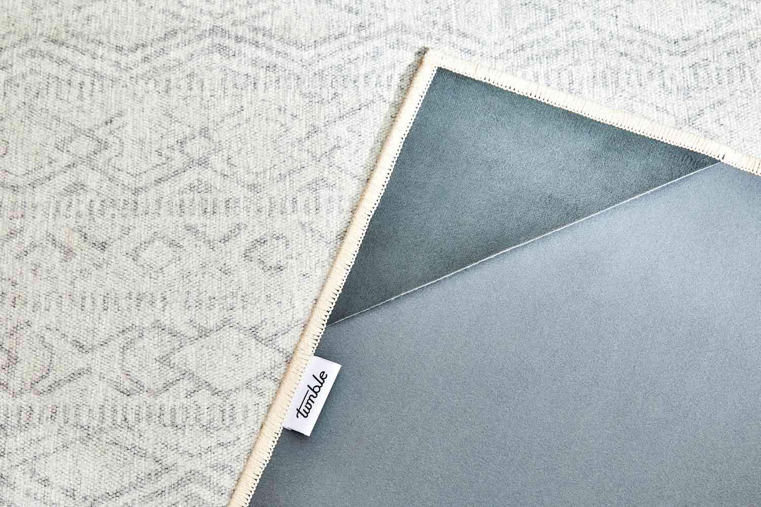 A close up on both sides of the Tumble Tabor Washable Rug & Cushioned Rug Pad