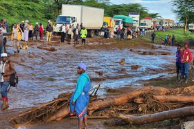 People gather on the main road after a dam burst, in Kamuchiri Village Mai Mahiu, Nakuru County, Kenya, Monday, April 29, 2024. Police in Kenya say at least 40 people have died after a dam collapsed in the country's west. 