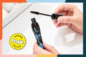 A person holding up the tub and applicator for the Essence Lash Princess False Effect Lash Effect Waterproof Mascara