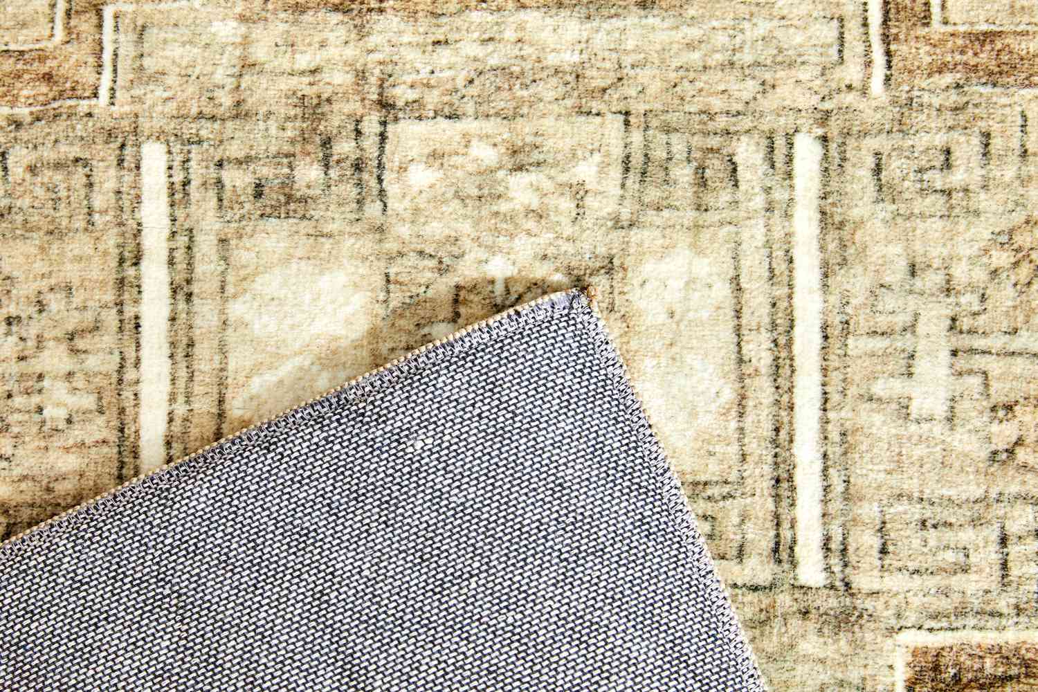 Close up of both sides of the Magnolia Home by Joanna Gaines x Loloi Sinclair Machine Washable Area Rug that is partially folded