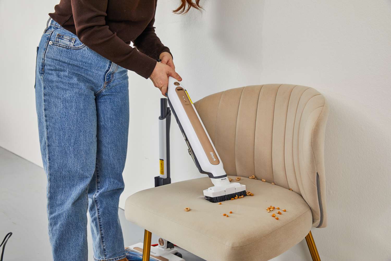 Women cleaning dust on the chair using Shark WS642AE Wandvac Cordless Stick Vacuum with Self-Empty Charging
