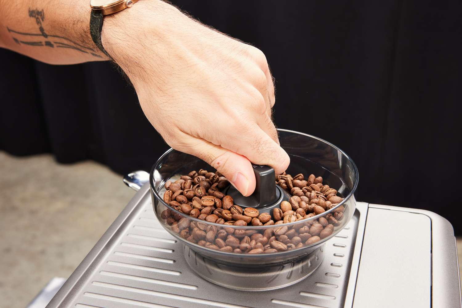 A person adjusting the grind on the Breville Barista Express Impress.