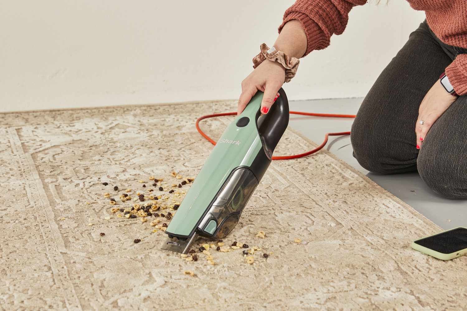 Person using the Shark UltraCyclone Pro Cordless Handheld Vacuum to clean food from carpet