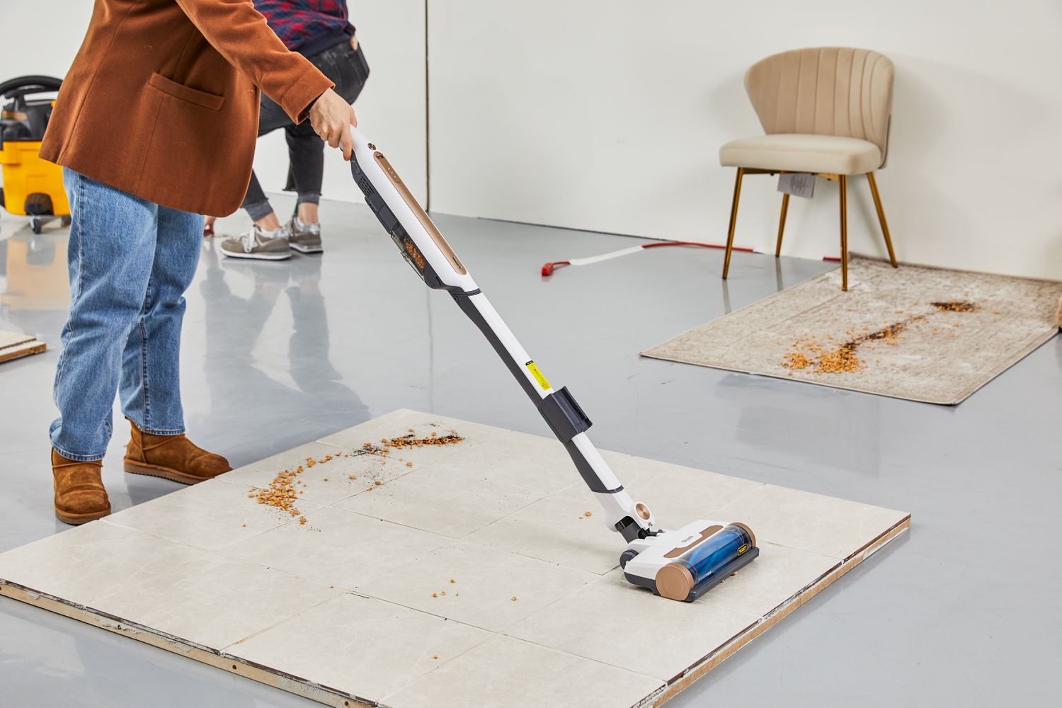 Women cleaning dust on piece of tile floor using Shark WS642AE Wandvac Cordless Stick Vacuum with Self-Empty Charging