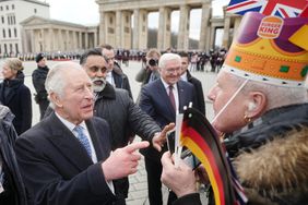 29 March 2023, Berlin: King Charles III of Great Britain (front l) greets fans at the Brandenburg Gate alongside German President Frank-Walter Steinmeier. Before his coronation in May 2023, the British king and his royal wife will visit Germany for three days.