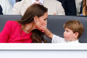 Prince Louis of Cambridge covers his mother Catherine, Duchess of Cambridge's mouth with his hand as they attend the Platinum Pageant