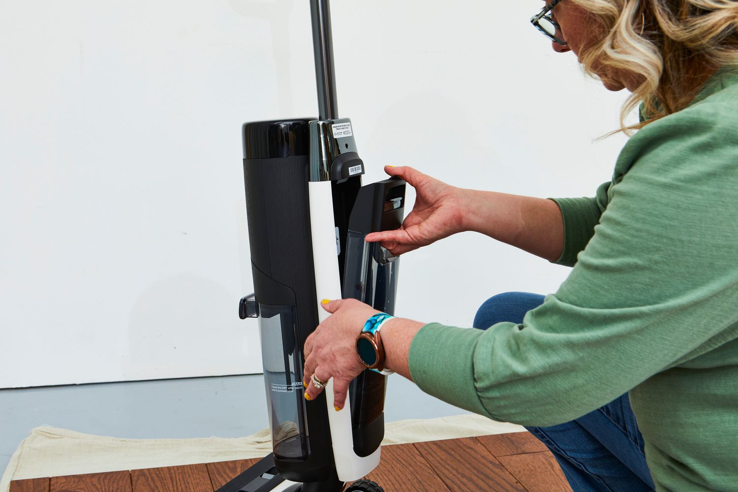 A person putting a compartment back into the Tineco Floor One S7 Pro Smart Wet Dry Vacuum Cleaner