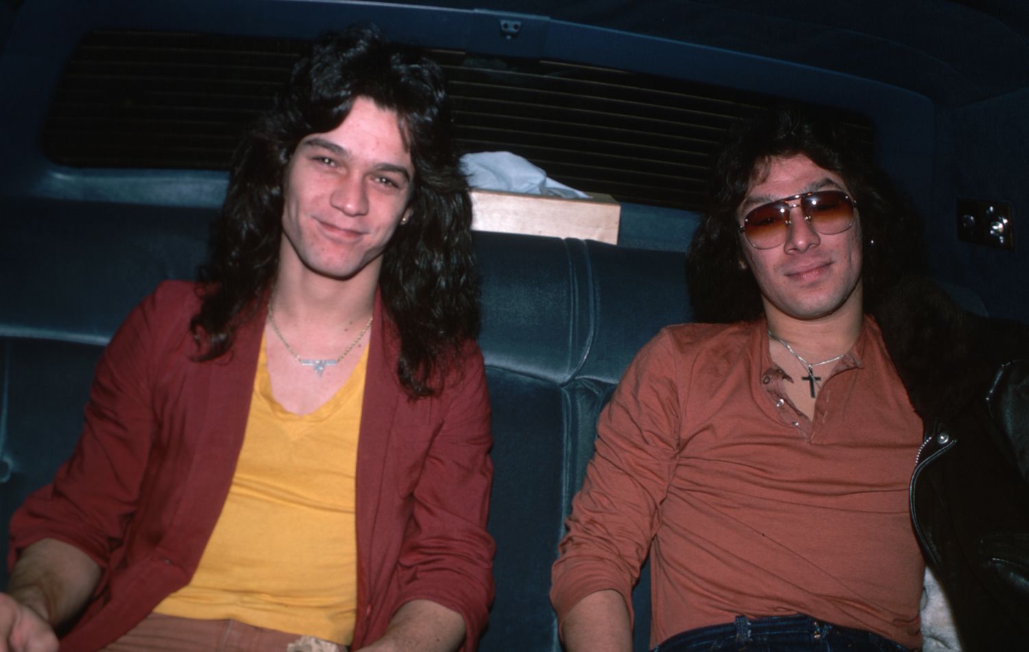 Informal portrait of Eddie and Alex Van Halen. They are shown waist-up, in the back seat of an automobile.