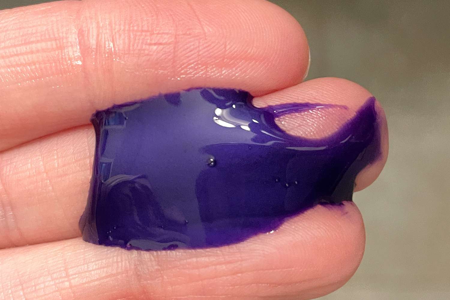 Close-up of fingers holding a small amount of Verb Purple Shampoo