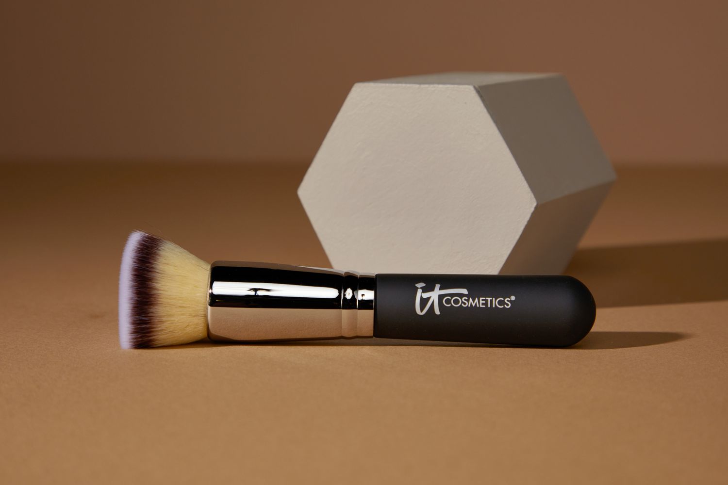 It Cosmetics Heavenly Luxe Flat Top Buffing Foundation Brush #6 laying in front of a hexagon block