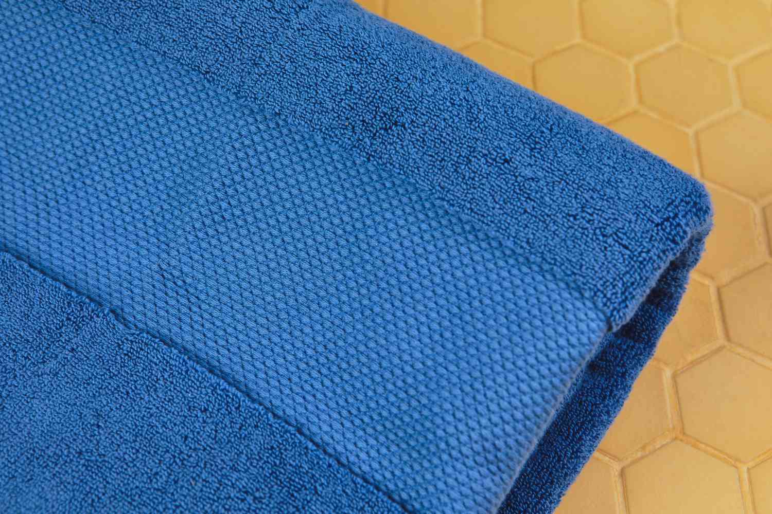 Closeup of Frontgate Resort Collection Bath Towel on yellow tile surface