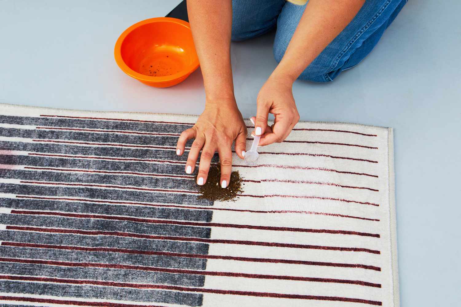 A person touching dirt on the Ruggable Gradasi Premium Rug