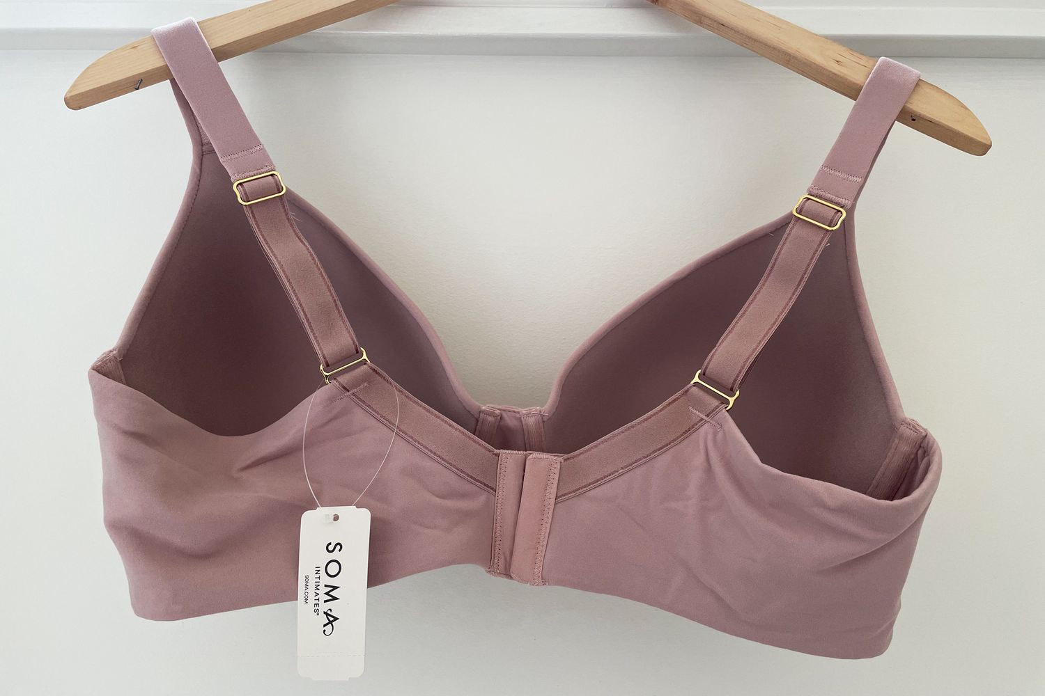 The back of a Soma Embraceable Full Coverage Wireless Unlined Bra hanging on a wood hanger
