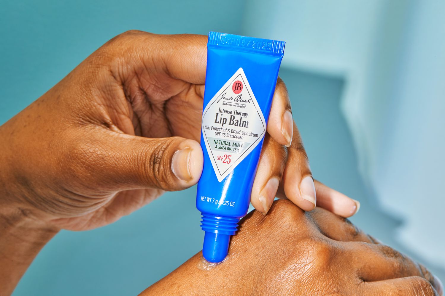Jack Black Intense Therapy Lip Balm being squeezed onto the back of a hand