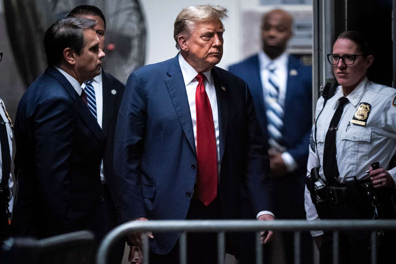 Former US President Donald Trump, center, returns from a break at Manhattan criminal court in New York, US, on Monday, April 15, 2024. Jury selection beings Monday in Trump's criminal trial where he faces 34 felony counts of falsifying business records as part of an alleged scheme to silence claims of extramarital sexual encounters during his 2016 presidential campaign. 