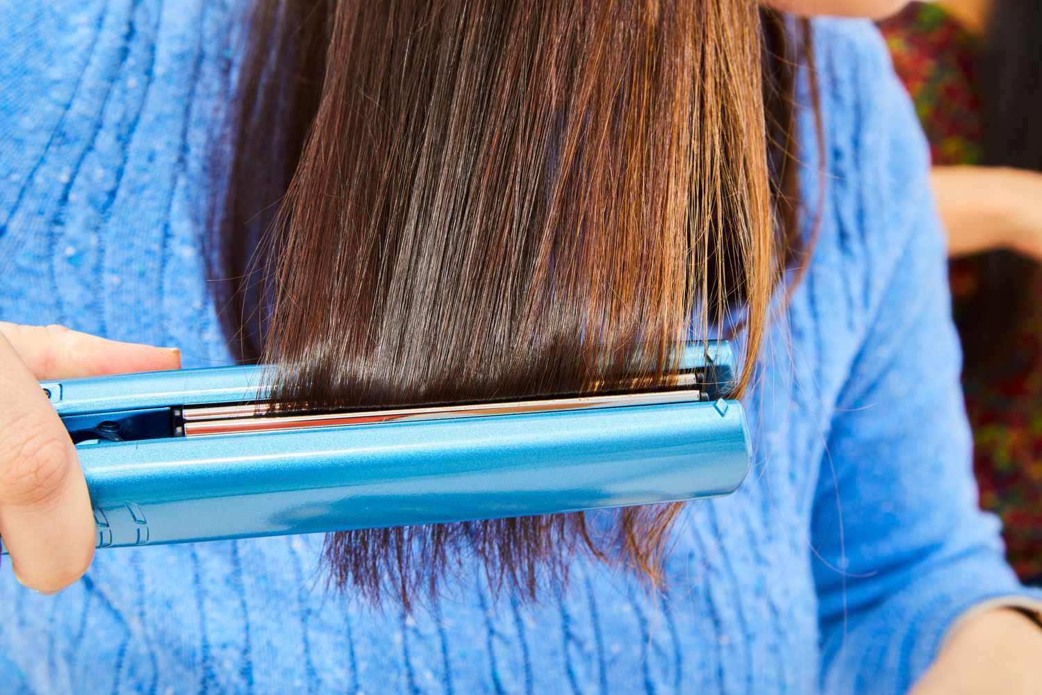 person straightens hair after using dpHUE Color Fresh Thermal Protection Spray
