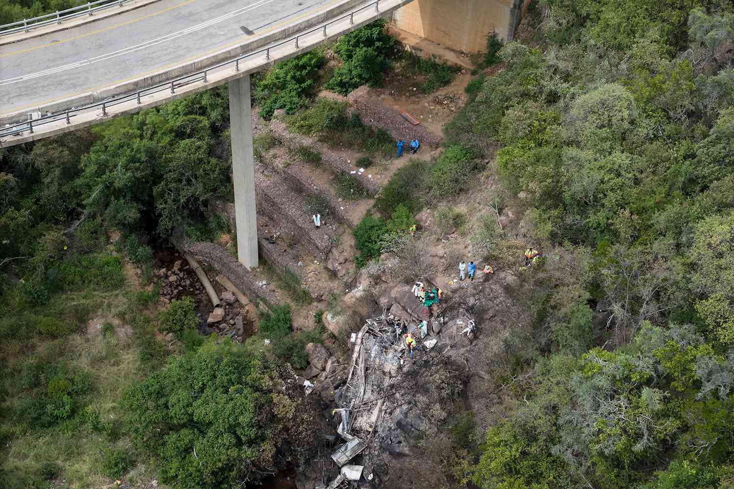 Emergency services and rescue workers attend to the site of a bus crash in the Mamatlakala mountain pass in Limpopo province, South Africa, 29 March 2024. According to South Africa's transport ministry, 45 people died in the crash after the bus the previous day drove of a bridge. The bus was carrying passengers from Botswana to town of Moria for a local Easter religious gathering.