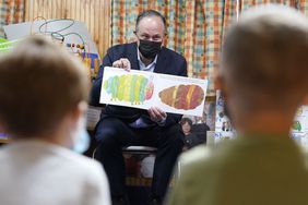 Douglas Emhoff, center, husband of Vice President Kamala Harris, reads The Very Hungry Caterpillar, by Eric Carle, to a group of pre-school children at Mother Hubbard Pre-School Center, in Milford, Mass.