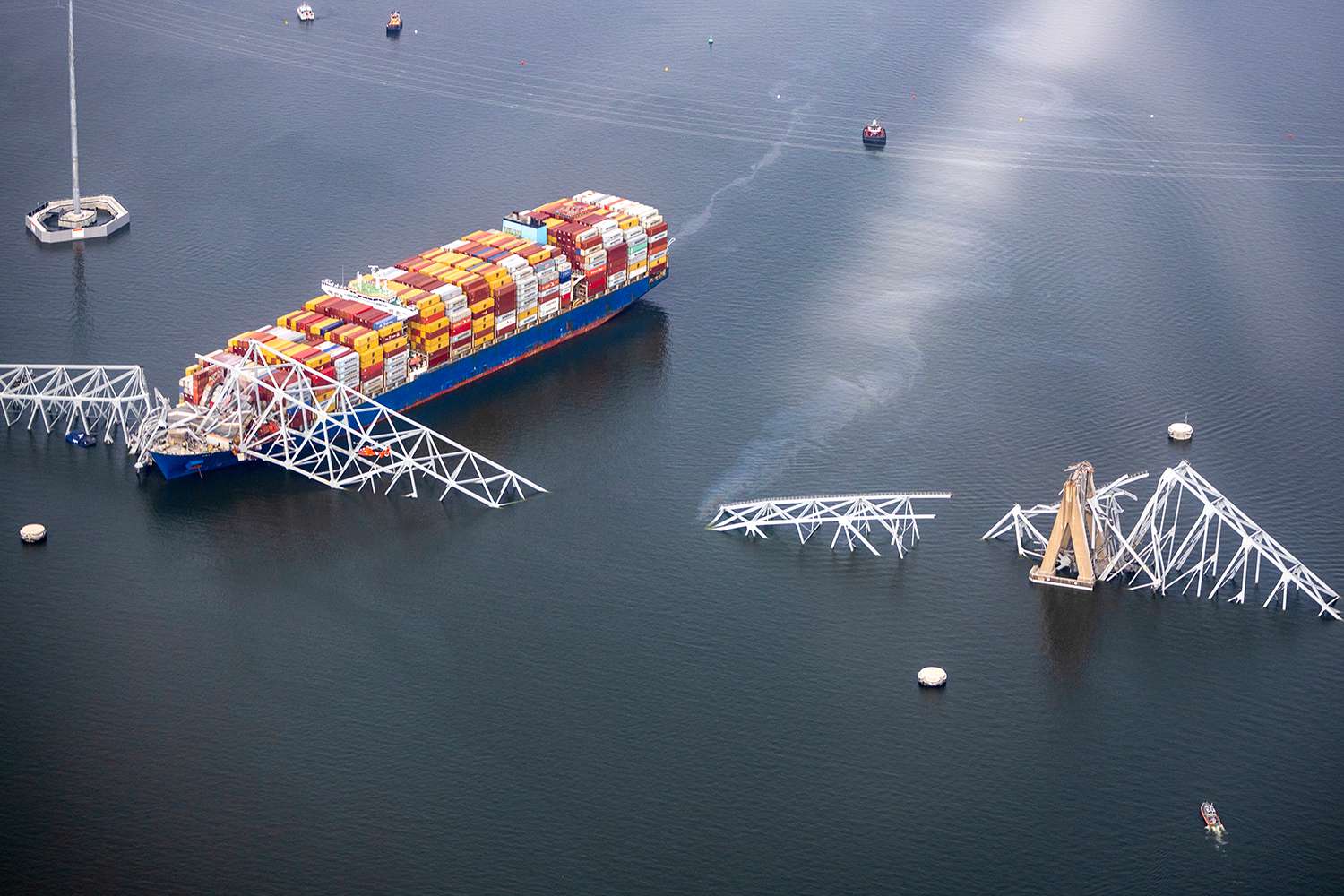In an aerial view, cargo ship Dali is seen after running into and collapsing the Francis Scott Key Bridge on March 26, 2024 in Baltimore, Maryland. Rescuers are searching for at least seven people, authorities say, while two others have been pulled from the Patapsco River.