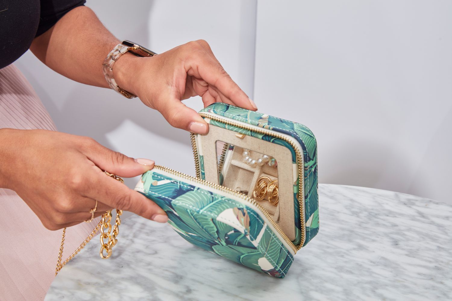 A person opening the filled Mark & Graham Small Travel Jewelry Case.