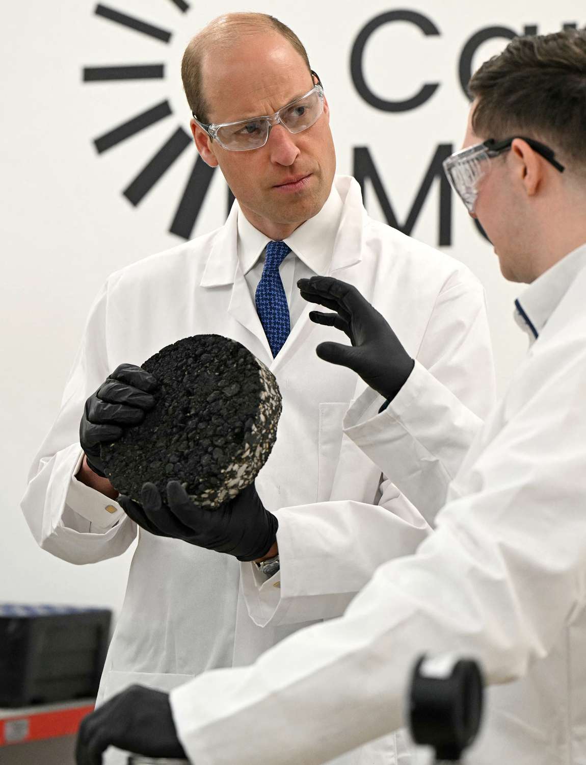 Prince William, Prince of Wales reacts as he is shown a sample of low carbon tarmac during his visit to visit Low Carbon Materials in Seaham, 