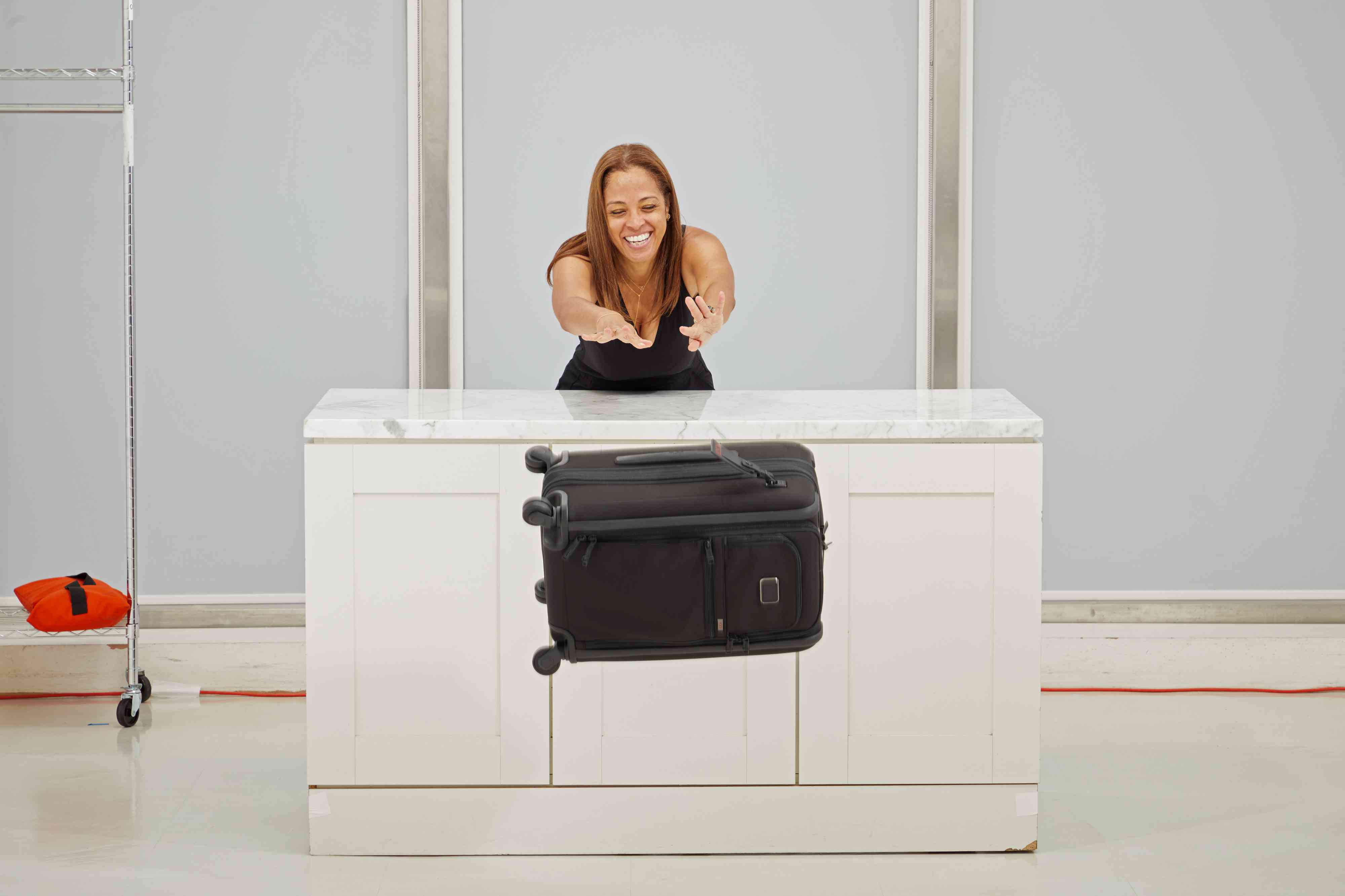 Tumi Alpha International Dual Access 4 Wheeled Carry-On being pushed off of a counter