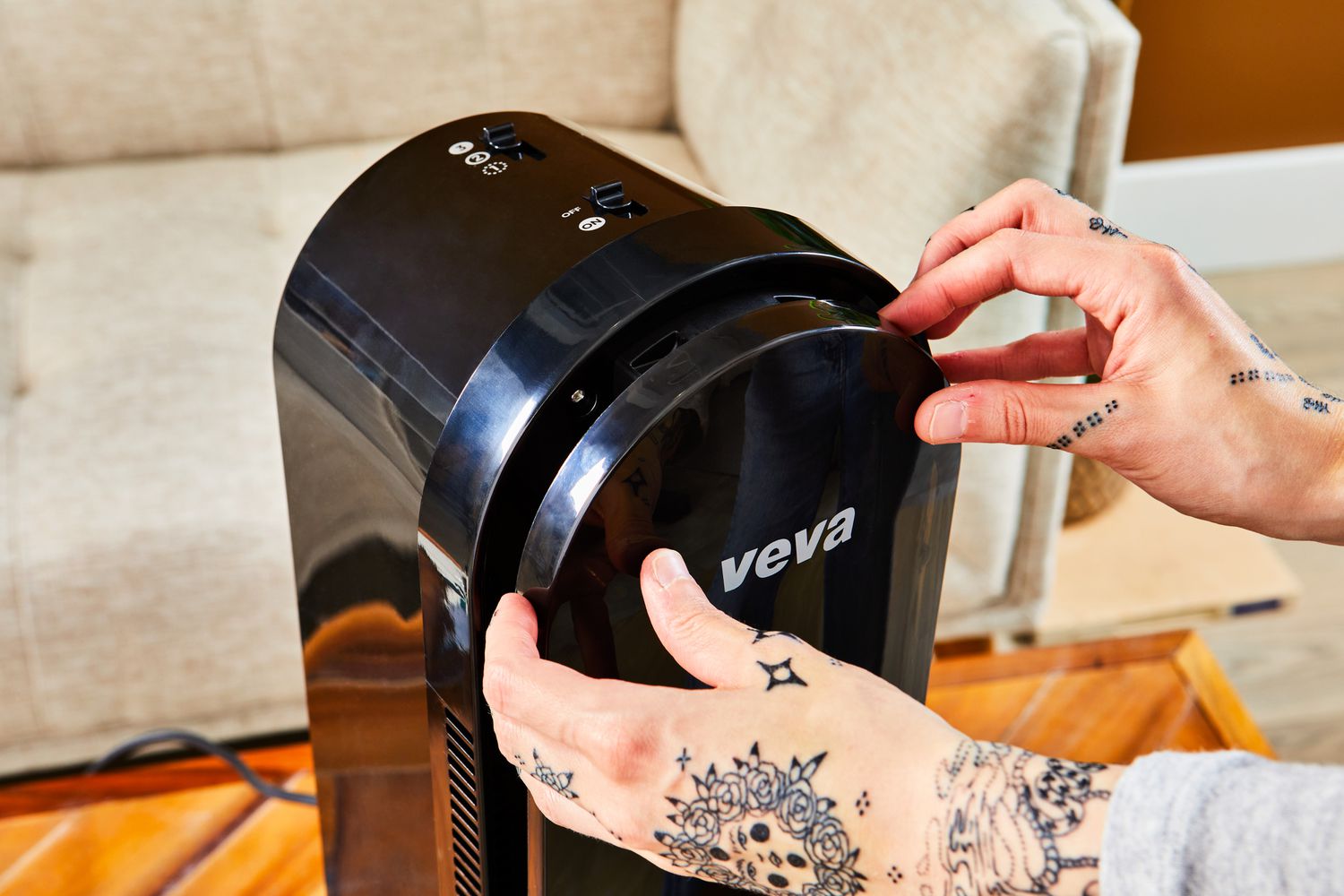 A person removing the cover of the VEVA 8000 Black Air Purifier