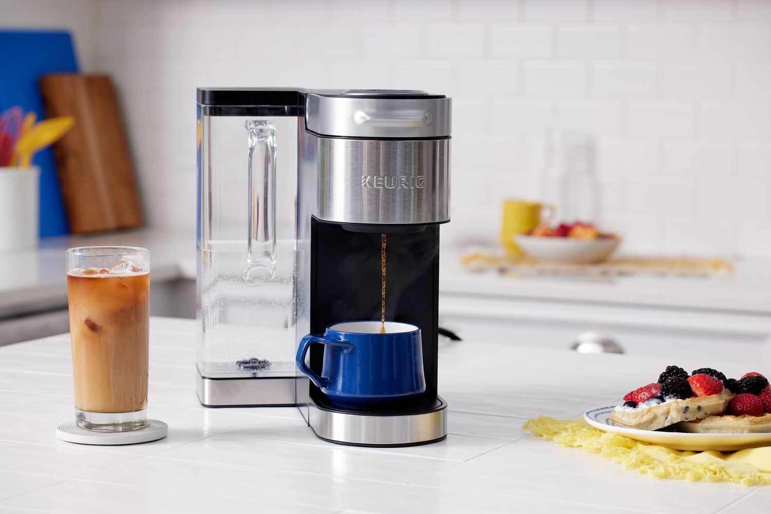 Keurig K-Supreme Plus pouring a cup of coffee next to a plate of pancakes
