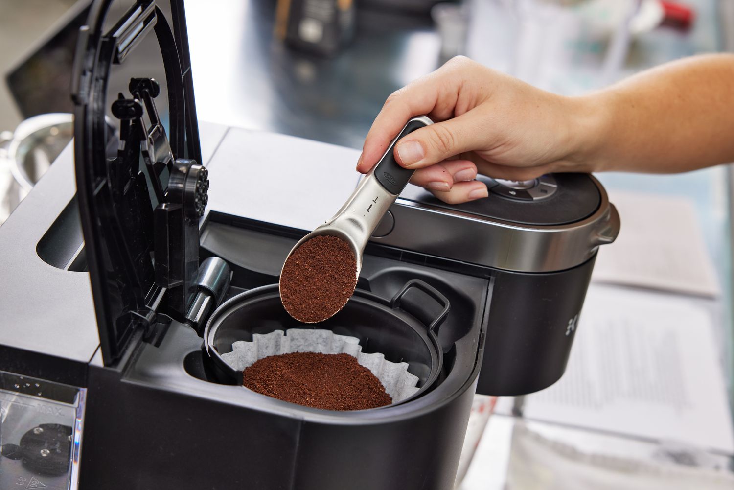 Hand pouring coffee into the Keurig K-Duo Coffee Maker