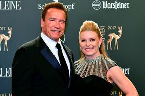 Arnold Schwarzenegger and his partner Heather Milligan pose on the red carpet