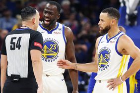 The Golden State Warriors' Draymond Green (23) screams at game official Ray Acosta (54) as teammate Stephen Curry (30) steps in at right during action against the Orlando Magic at the Kia Center on Wednesday, March 27, 2024, in Orlando, Florida. 