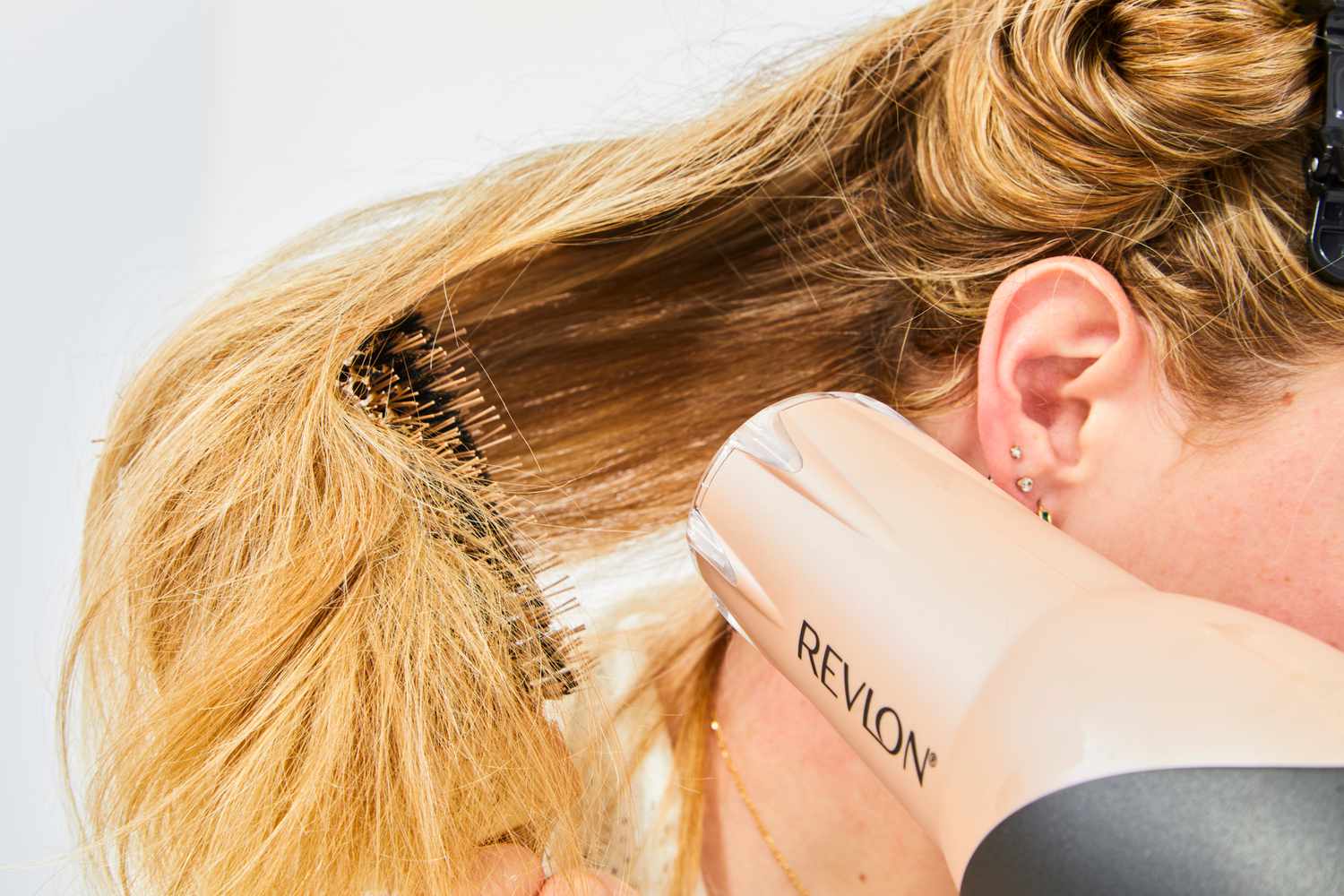 person blow dries hair after using Olaplex No. 9 Bond Protector Nourishing Hair Serum