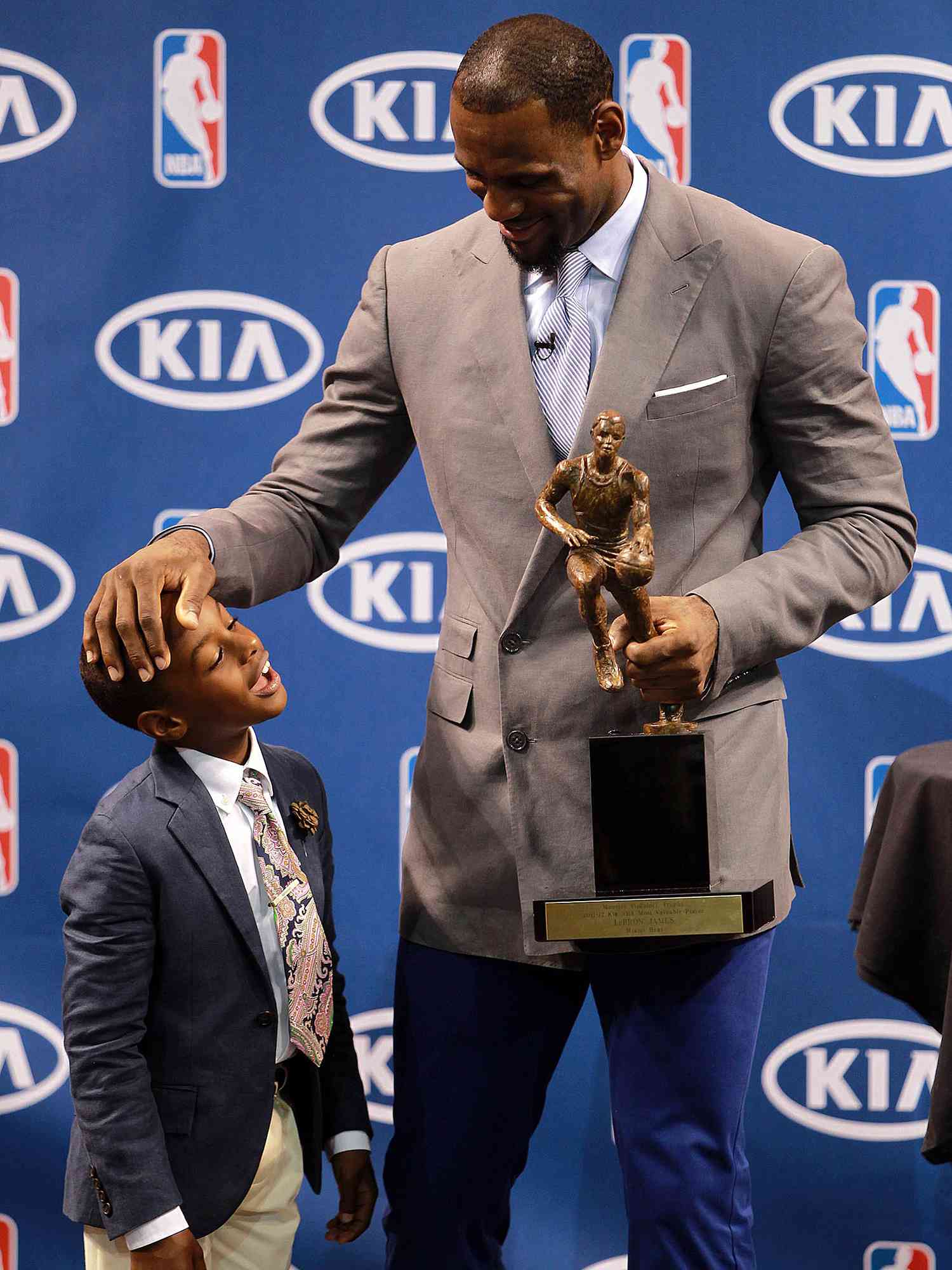 Lebron James holds the NBA Most Valuable Player trophy with son, Lebron Jr