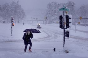  A pedestrian navigates a snow-covered sidewalk on January 09, 2024 in Iowa City, Iowa.