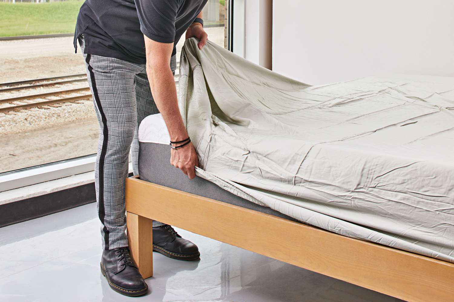 person pulling Luxome Luxury Sheet over the corner of a mattress