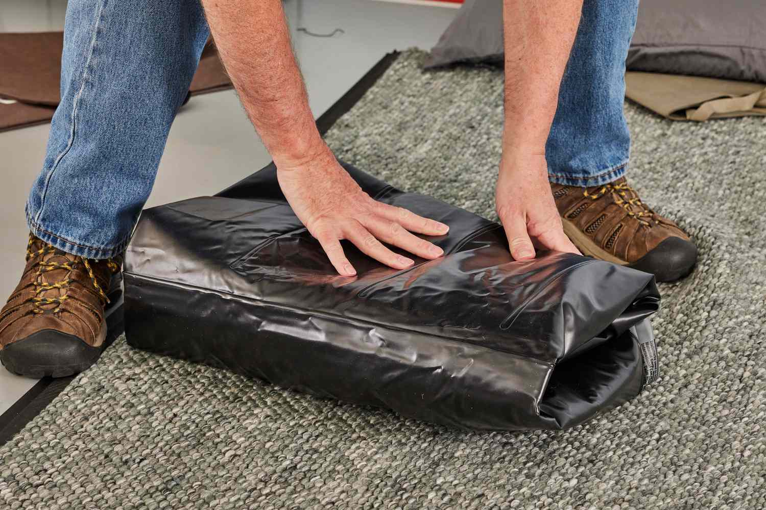 A person folds up the Bestway Tritech Air Mattress with Built-in Pump