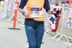 Christy Turlington Burns raises her arms in victory as she nears the end of the New York City Marathon!
