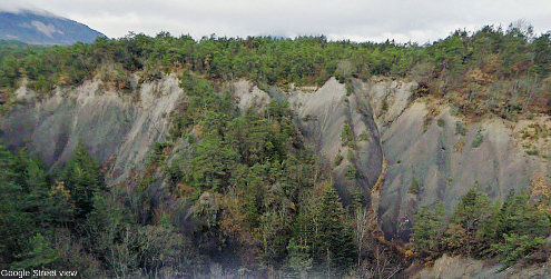 Vue Google Street view du contact stratigraphique entre terrains lacustro-glaciaires du Würm (gris-beige clair) reposant sur les marnes noires du Bathonien