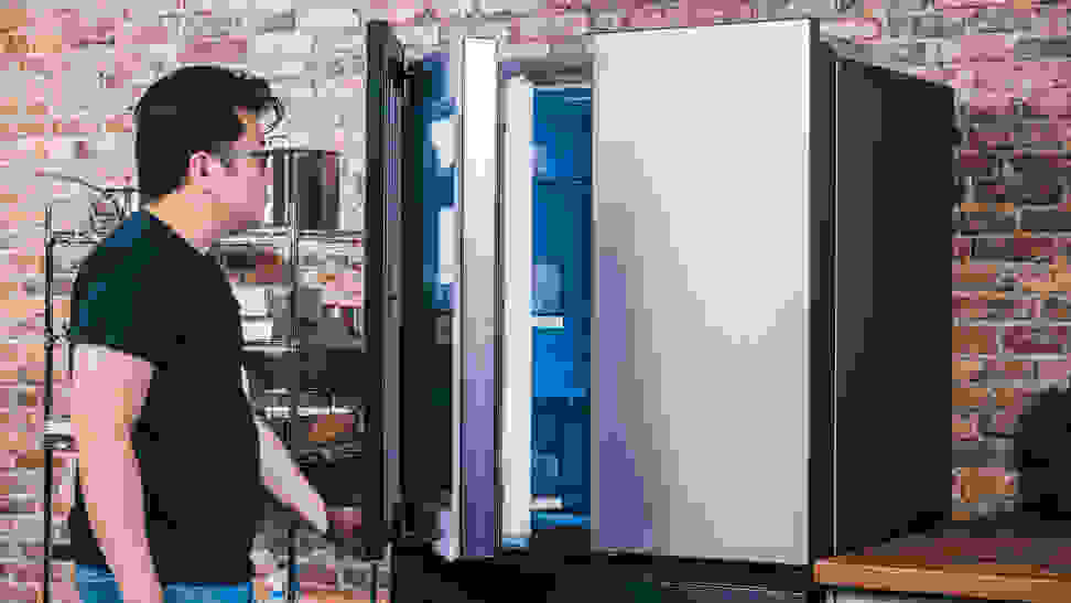 A person pulling a door open on a French-door refrigerator