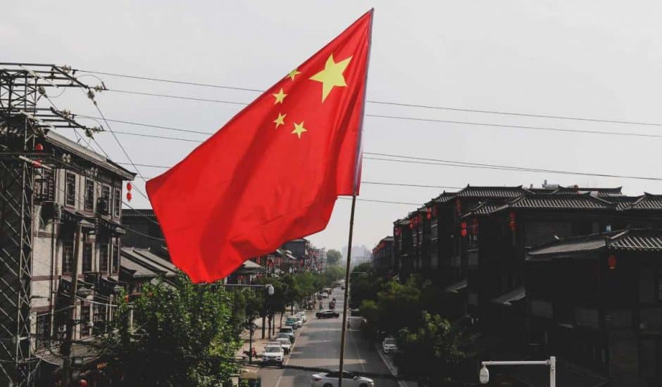 Le drapeau chinois flotte devant une rue.